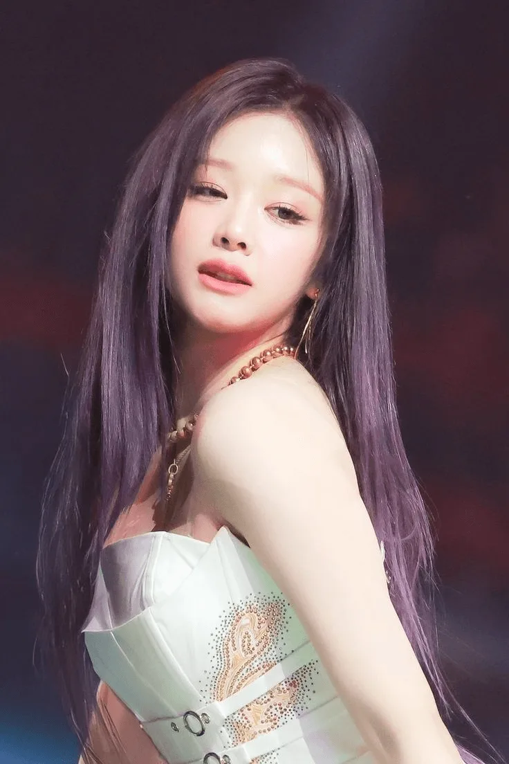 File photo of Pharita with long purple hair, wearing a white stage outfit. · On-site photo · Photographed in 2026